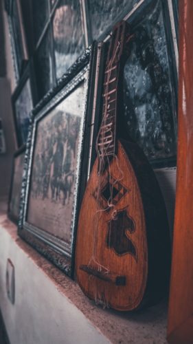 A historical lute propped next to an old painting A historical lute propped next to an old painting